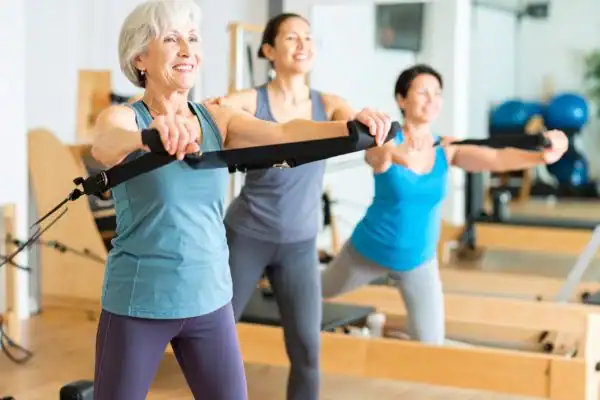 Toning Arms After 60: Empowering Womens Fitness Through Effective Weight Training 2 older woman doing weight training Birch and resistance in the gym to tone upper arms