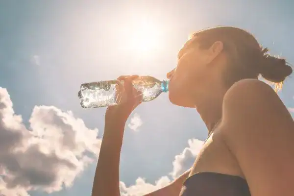 Hydration: The Secret Ingredient for a Toned Stomach and Enhanced Fitness 3 Image of woman drinking water to hydrate Birch after run.